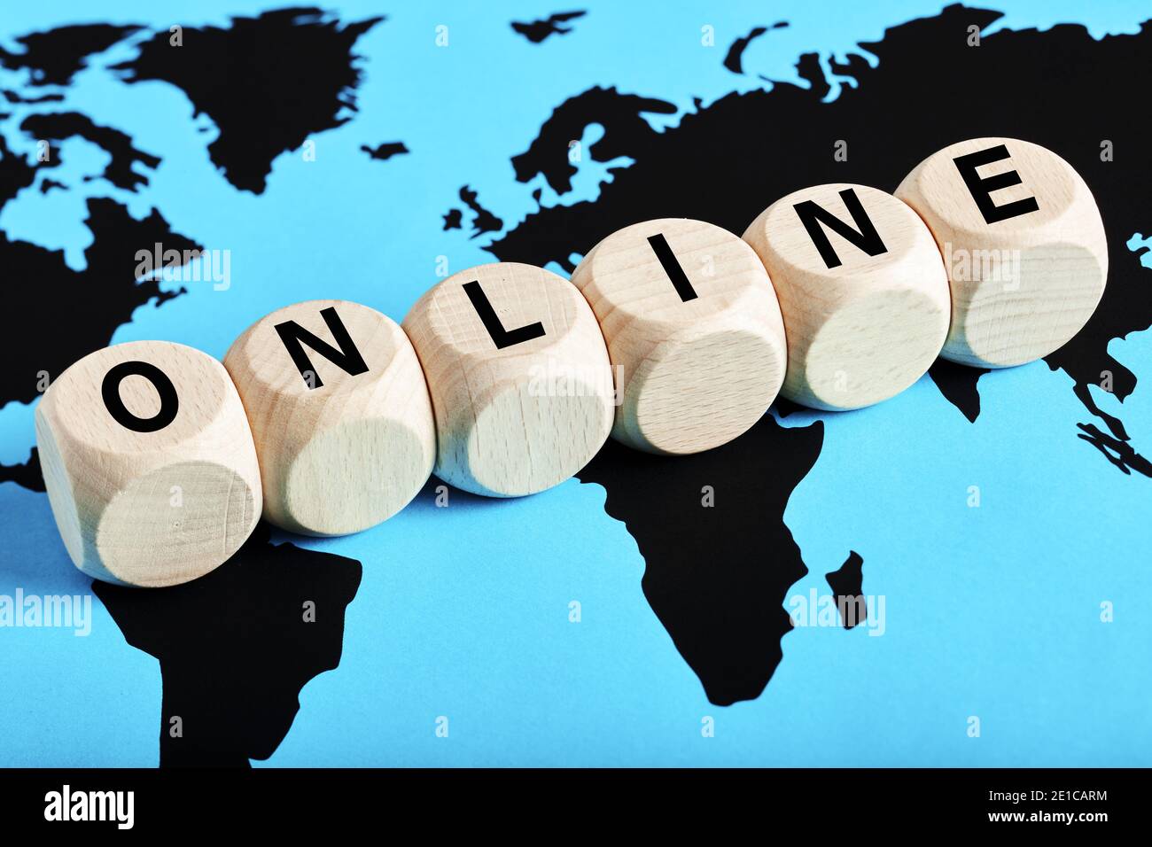 La parola online scritta su cubi di legno sullo sfondo della mappa del mondo. La comunità online globale, la comunicazione mondiale o il concetto di business online. Foto Stock