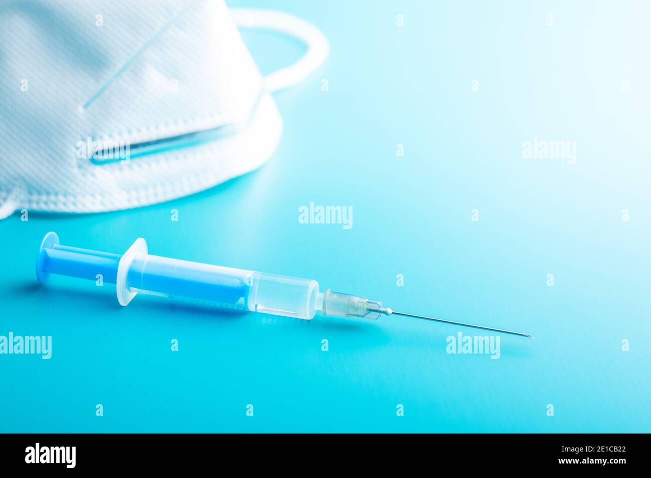 Siringa per iniezione. Vaccinazione con il coronavirus di Covid-19. Vaccino del virus corona su sfondo blu. Foto Stock