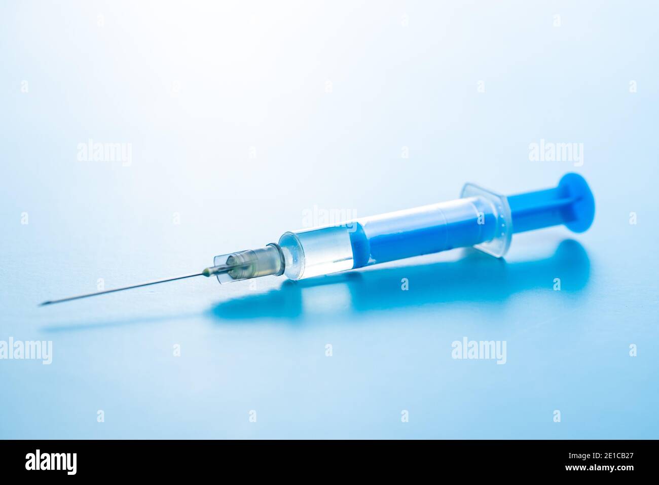 Siringa per iniezione. Vaccinazione con il coronavirus di Covid-19. Vaccino del virus corona su sfondo blu. Foto Stock