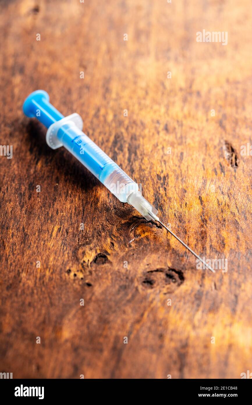 Siringa per iniezione. Vaccinazione con il coronavirus di Covid-19. Vaccino del virus corona su tavola di legno. Foto Stock