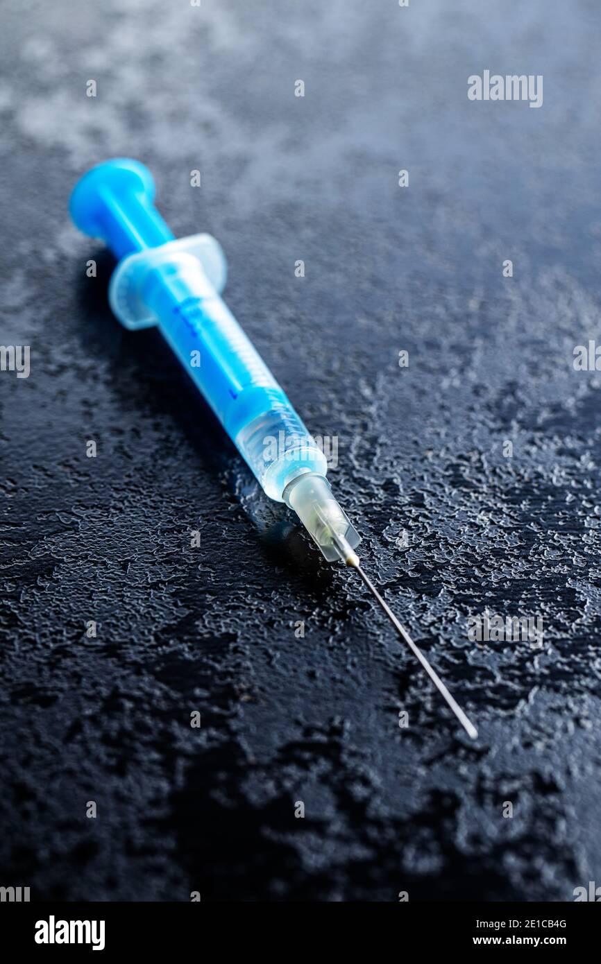 Siringa per iniezione. Vaccinazione con il coronavirus di Covid-19. Vaccino del virus corona su tavola nera. Foto Stock