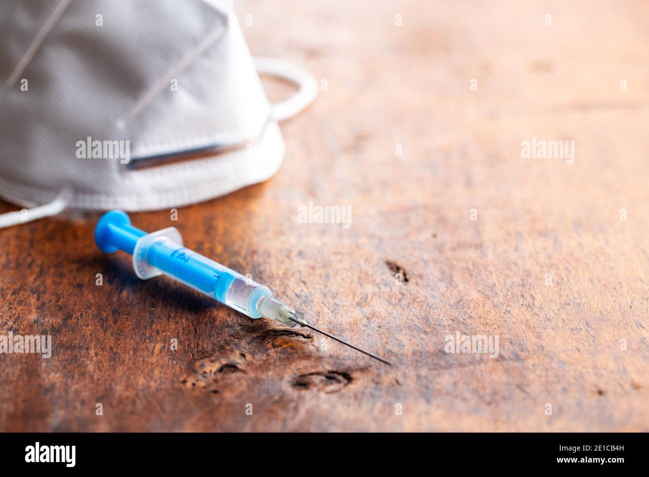 Siringa per iniezione. Vaccinazione con il coronavirus di Covid-19. Vaccino del virus corona su tavola di legno. Foto Stock