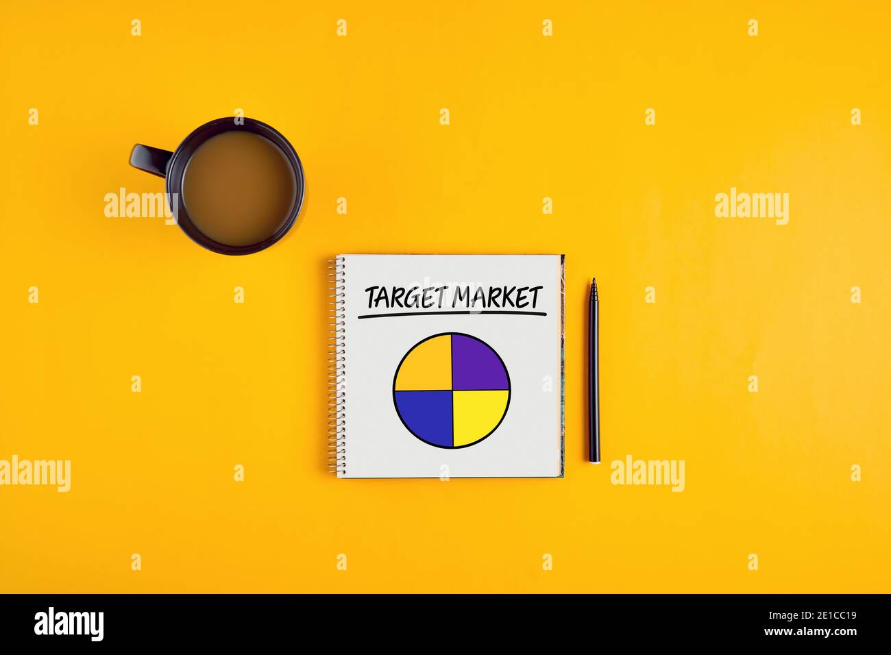 La parola mercato di destinazione e un grafico a torta su notebook con penna e tazza di caffè su sfondo giallo. Foto Stock