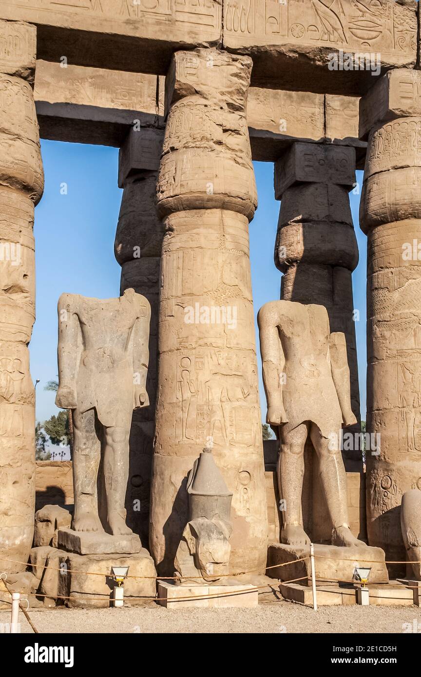 Luxor. Massicce colonne di pietra e statue senza testa di Ramesse II nel cortile interno del 3500 anni, patrimonio mondiale dell'UNESCO del tempio di Luxor, parte del più grande complesso di templi del mondo, Situato sul fiume Nilo, nella città di Luxor precedentemente conosciuta nel mondo antico come Tebe, la cui costruzione è in gran parte accreditata a Ramesse II, Ramesse il Grande. Foto Stock