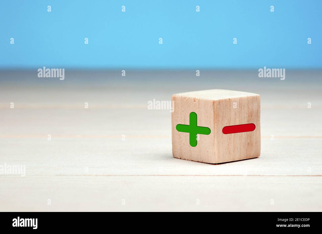 Blocco di legno con icone più e meno. Valutazione, valutazione, scelta o concetto decisionale. Foto Stock