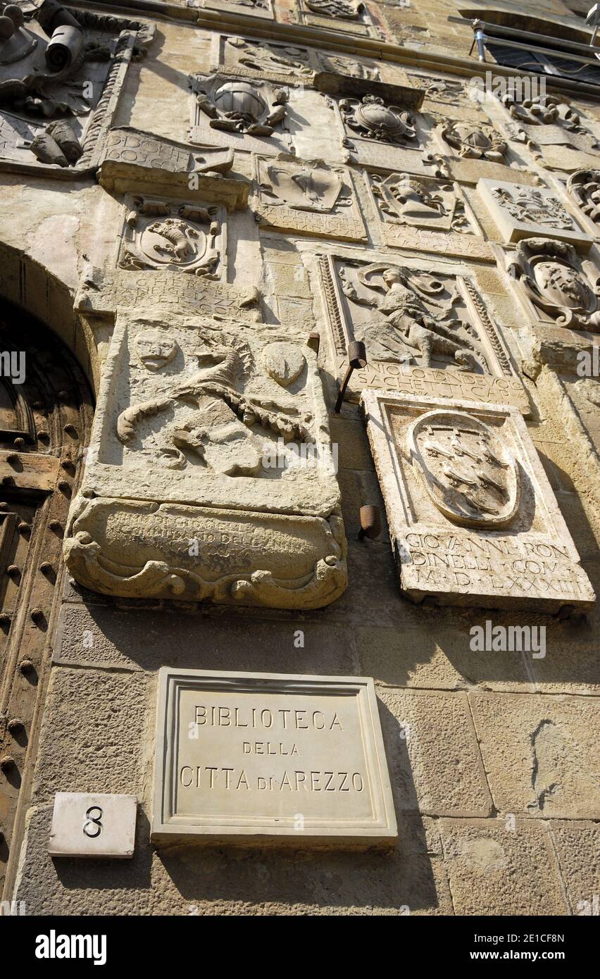 Arezzo, Toscana, Italia. Facciata del Palazzo Pretorio/Biblioteca Comunale (Biblioteca) in Via dei Pileati con stemmi in pietra Foto Stock