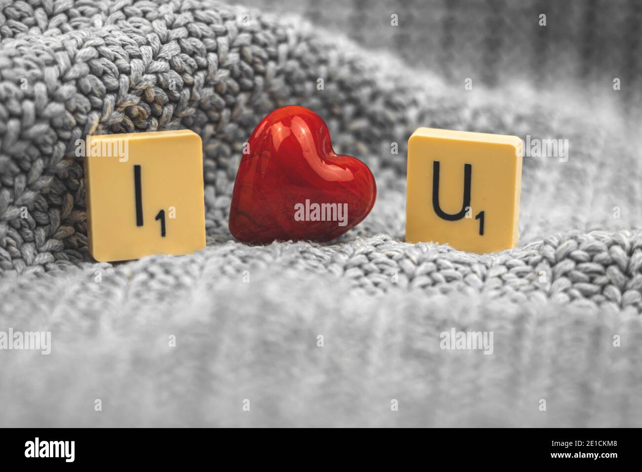 Concetto di San Valentino, ti amo composizione con cuore rosso vetro e scrabble a caldo maglia sfondo maglione Foto Stock
