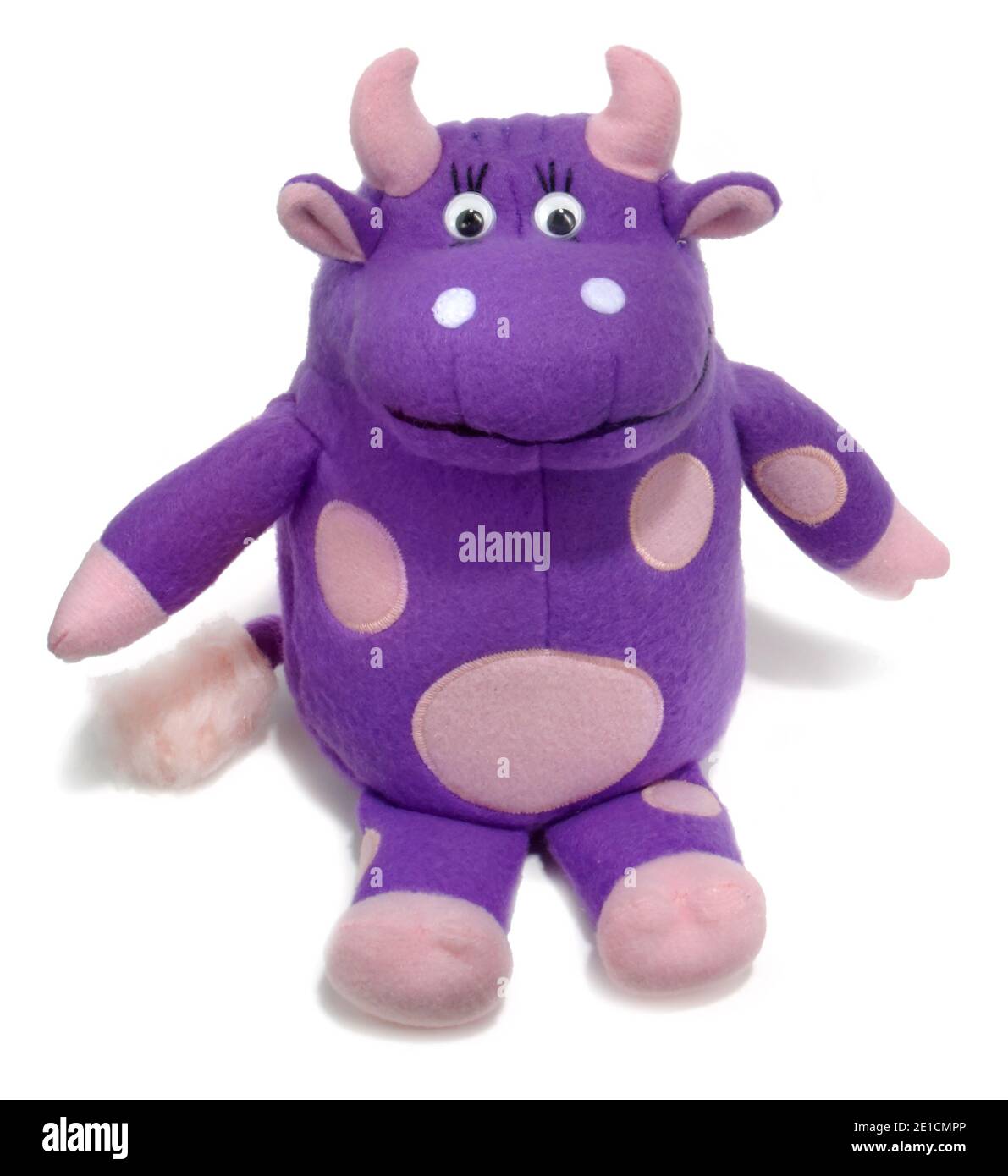 Peluche peluche di mucca viola fotografato su uno sfondo bianco. Foto Stock