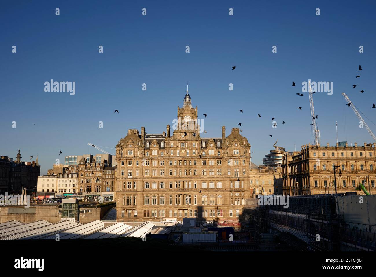 The Balmoral Hotel, Princes Street. Illuminato durante il sole diurno, in inverno di 2021. Uccelli che sorvolano Foto Stock