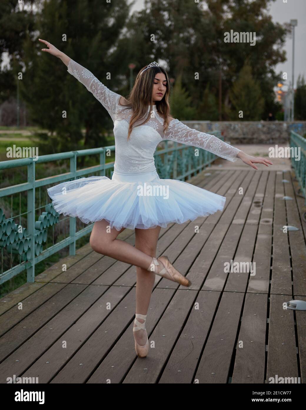 Ragazza ballerina adolescente che indossa abiti bianchi e scarpe da ballo punta balletto all'aperto Foto Stock