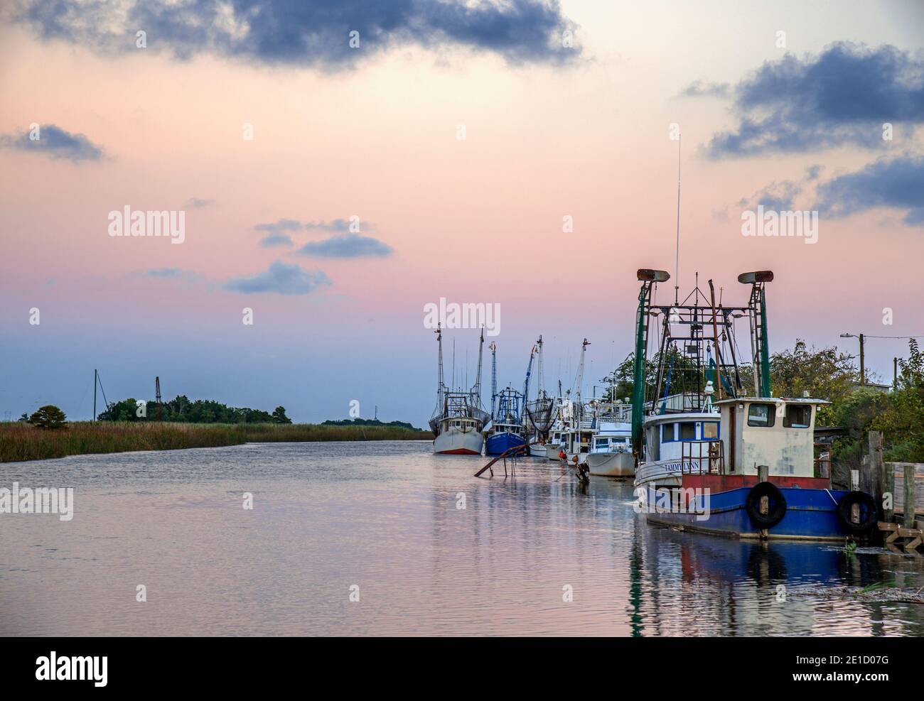 Barche da pesca ormeggiate lungo il fiume Apalachicola al tramonto, Florida, USA Foto Stock