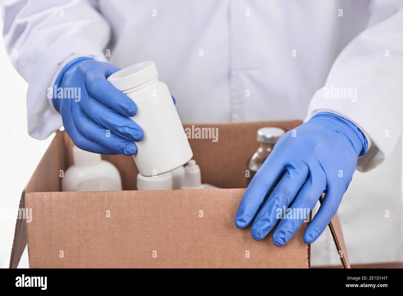 Medico che raccoglie i medicinali prescritti in una scatola di cartone Foto Stock