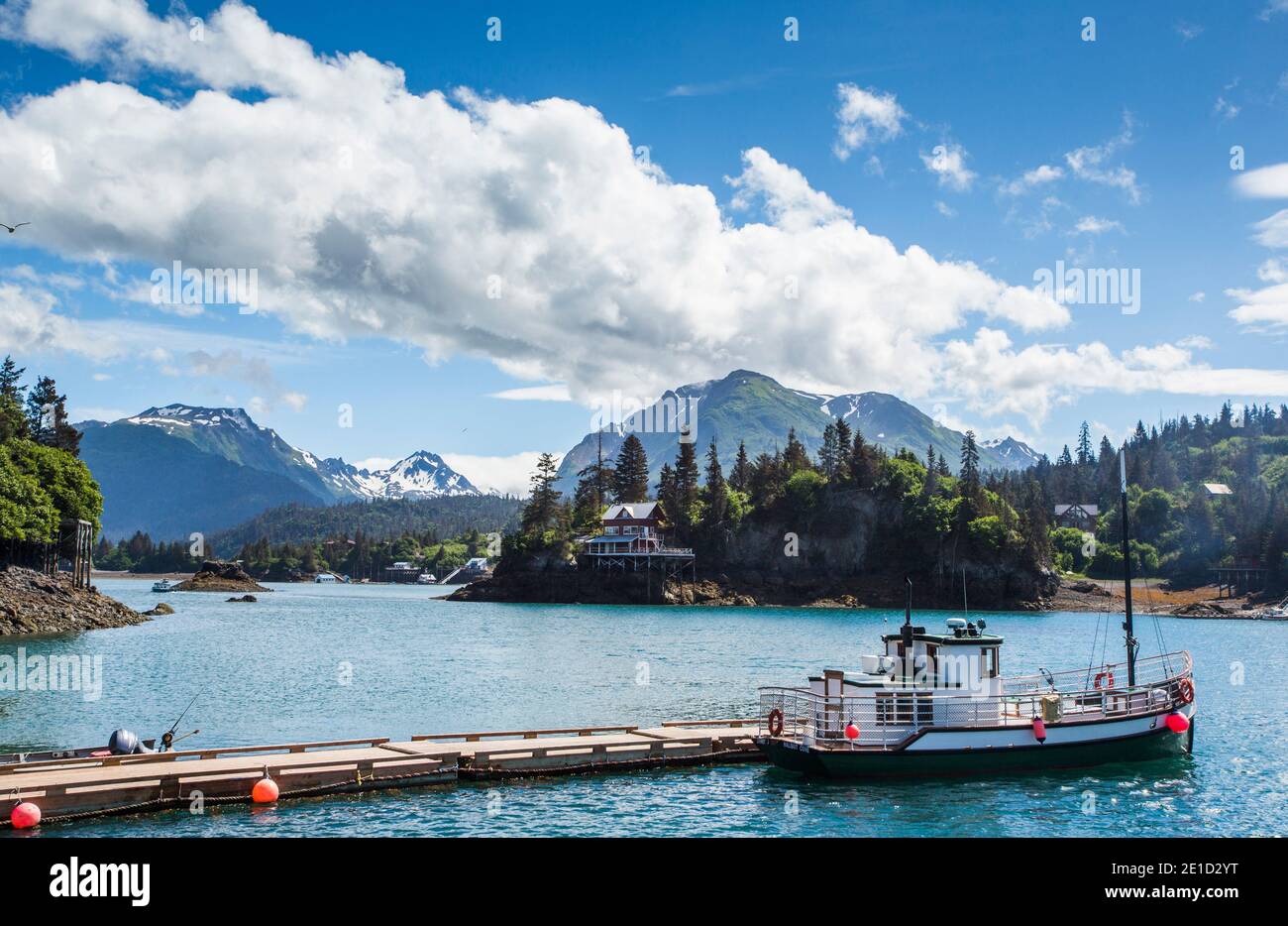 Una piccola barca è ormeggiata nelle acque calme di Halibut Cove, Alaska. Foto Stock