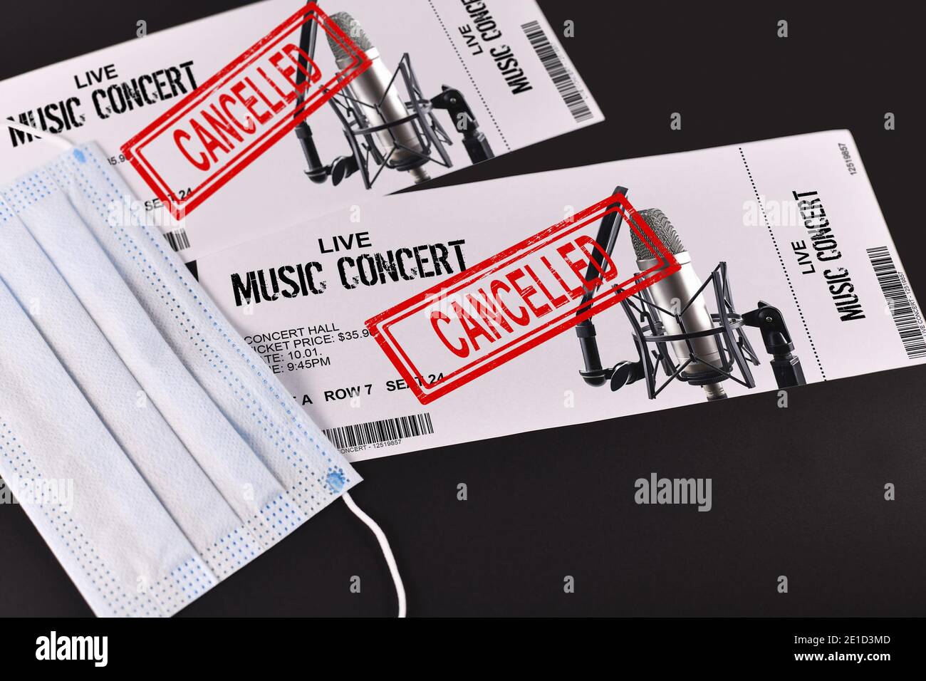 Concetto per eventi di intrattenimento annullati durante la pandemia di Corona virus con biglietti per concerti e francobollo rosso "cancellato" su di loro e sul viso maschera Foto Stock