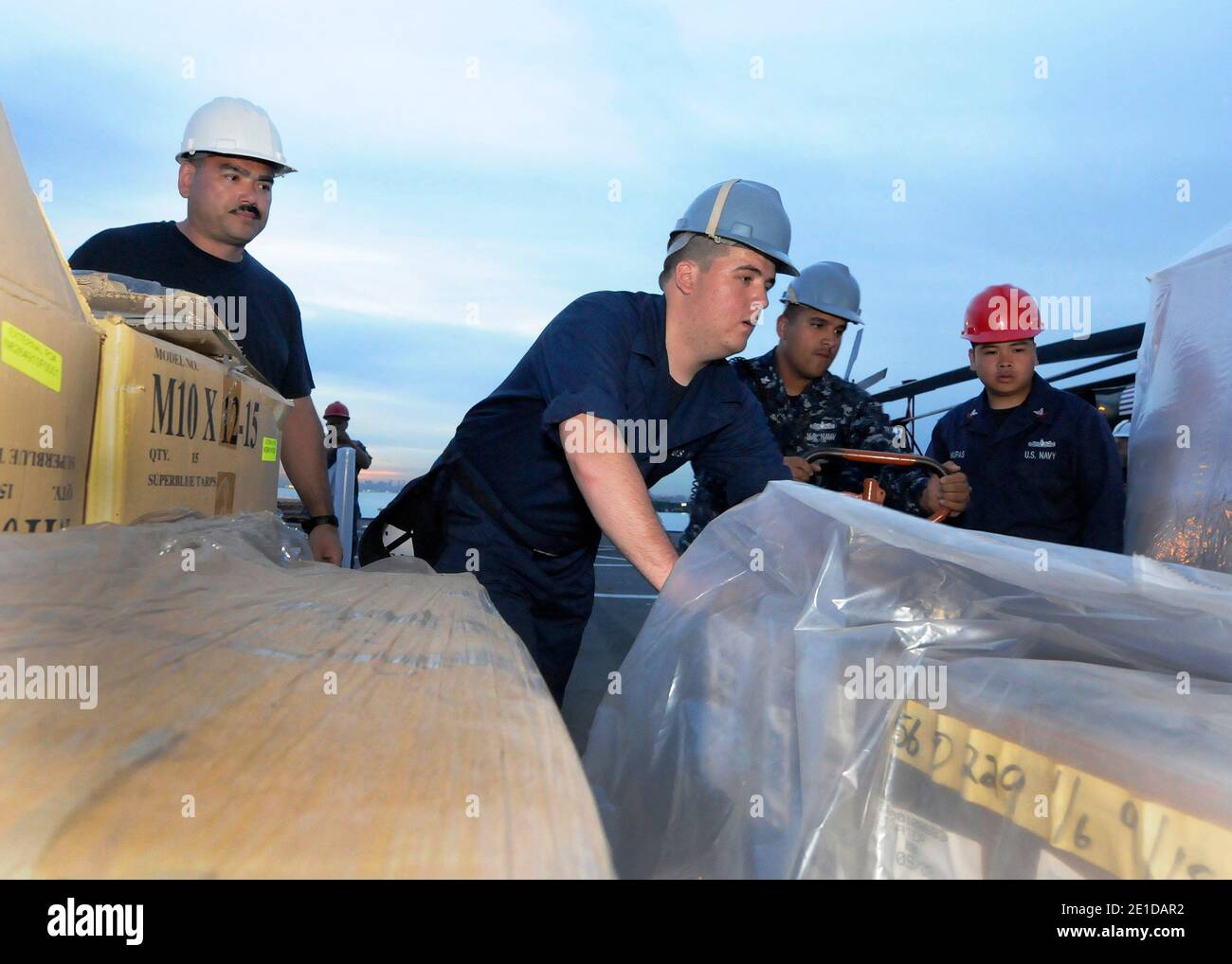 Master Chief Information Systems Technician Lonnie Gillian, a sinistra, Ship's Serviceman Seaman William Cody, Gunner's Mate 1° Classe Eduardo Soto e Operation's Specialist 2° Classe Glennaldrin Mupas caricano le forniture di assistenza umanitaria a bordo della settima nave di comando della flotta statunitense USS Blue Ridge (LCC 19) a Singapore, 11 marzo 2011, Garantire che la nave e l'equipaggio siano pronti, se diretti, a sostenere le operazioni di soccorso contro il terremoto e lo tsunami in Giappone. Foto di NVNS via ABACAPRESS.COM Foto Stock