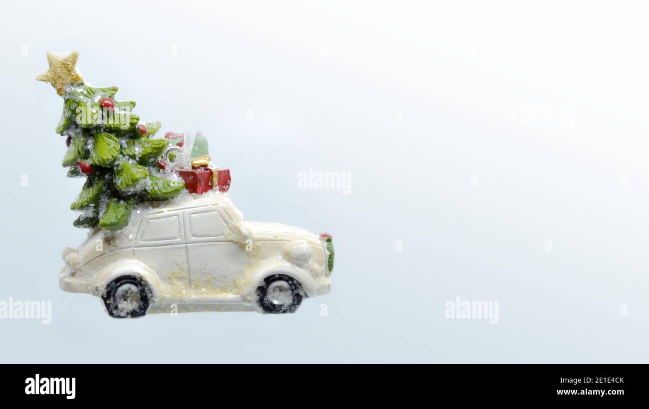 Sfondo di Natale con auto giocattolo, l'auto porta l'albero di Natale e regali, primo piano. Con spazio per la copia. Foto di alta qualità Foto Stock
