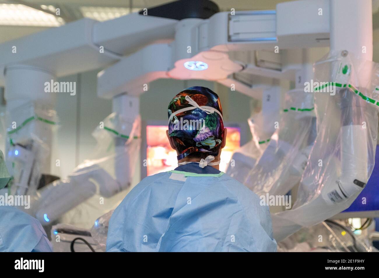 un chirurgo si trova di fronte a un robot che aziona un paziente Foto Stock