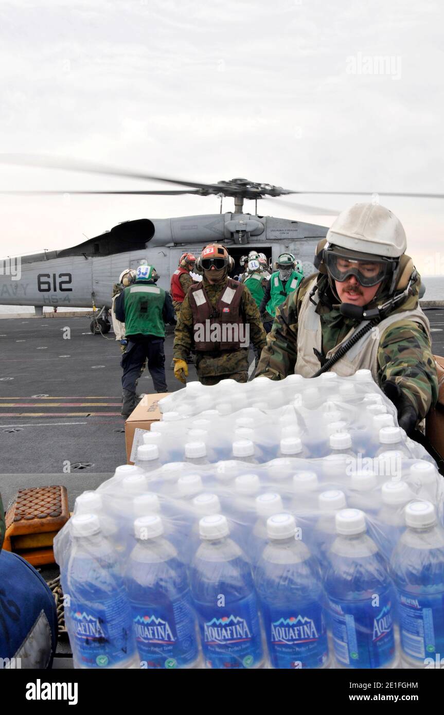 Marinai e marinai a bordo della portaerei USS Ronald Reagan (CVN 76) caricano forniture di assistenza umanitaria su un elicottero HH-60H Sea Hawk assegnato ai Cavalieri neri dello Squadrone anti-sottomarino (HS) 4 il 18 marzo 2011. Ronald Reagan opera al largo delle coste del Giappone fornendo assistenza umanitaria a sostegno dell'operazione Tomodachi. Foto di MCSN Nicholas A. Groesch/NVNS/ABACAPRESS.COM Foto Stock