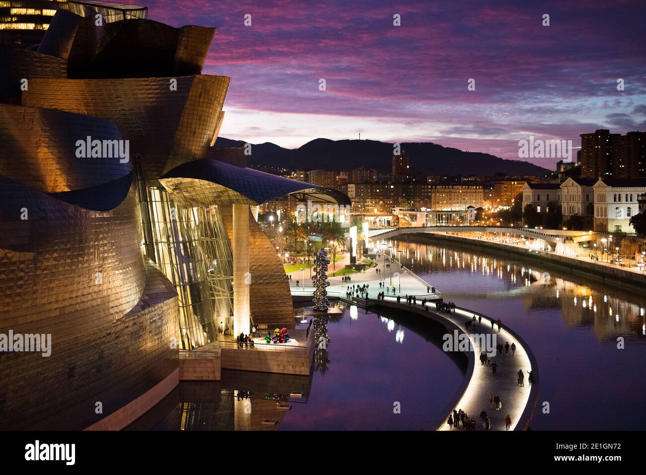 Vista esterna della facciata curva in titanio e vetro del Museo Guggenheim di Bilbao, Paesi Baschi, Spagna al tramonto. Foto Stock