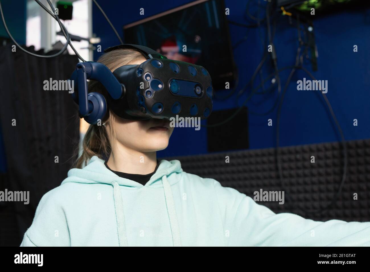 Ragazza teenager che usa il visore per la realtà virtuale nella stanza buia del club di gioco vr. Concetto di simulazione virtuale, gioco, internet delle cose. Foto Stock
