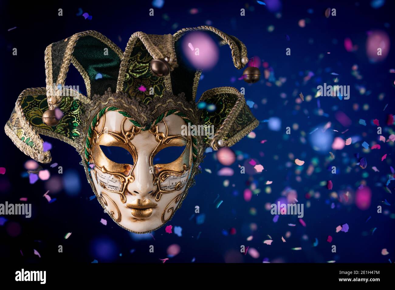 Maschera di carnevale veneziana tra i confetti volanti Foto Stock