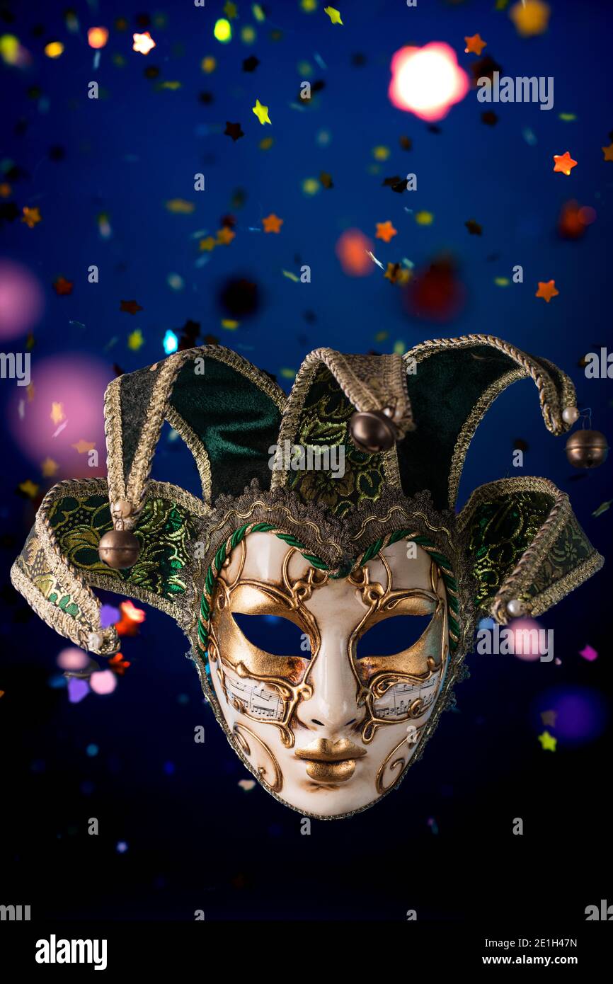 Maschera di carnevale veneziana tra i confetti volanti verticali Foto Stock