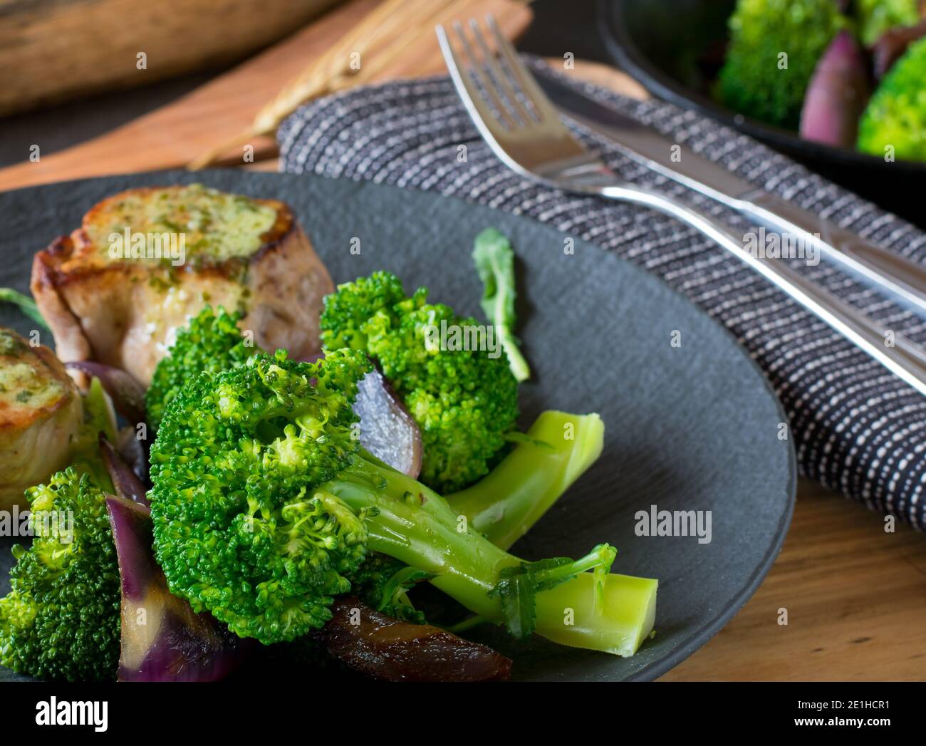 Fiori di broccoli al vapore su un piatto scuro con carne Foto Stock