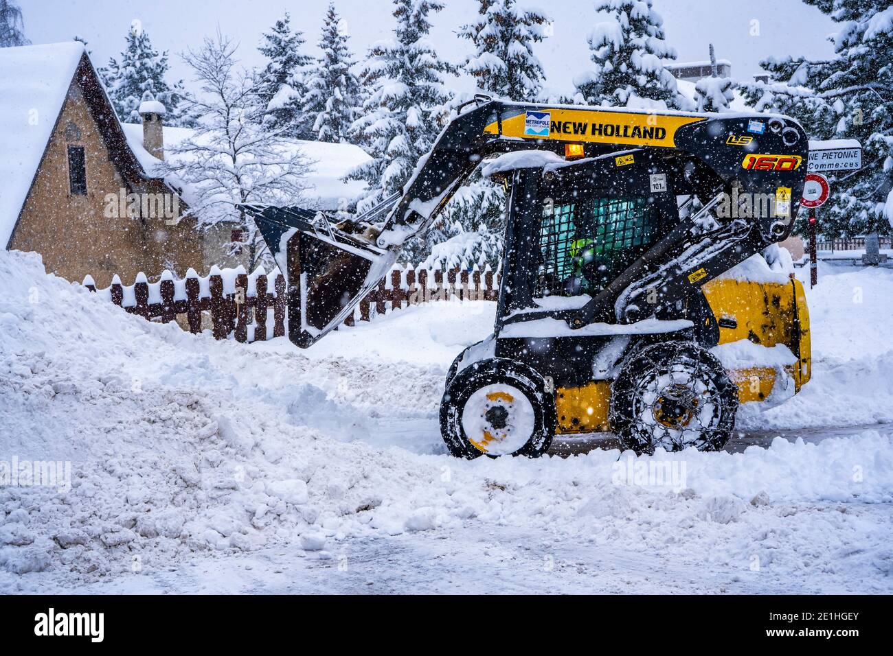 Auron, Francia 01.01.2021 pala gommata che rimuove la neve su una stazione sciistica. Eliminare la strada dalla neve. Foto di alta qualità Foto Stock