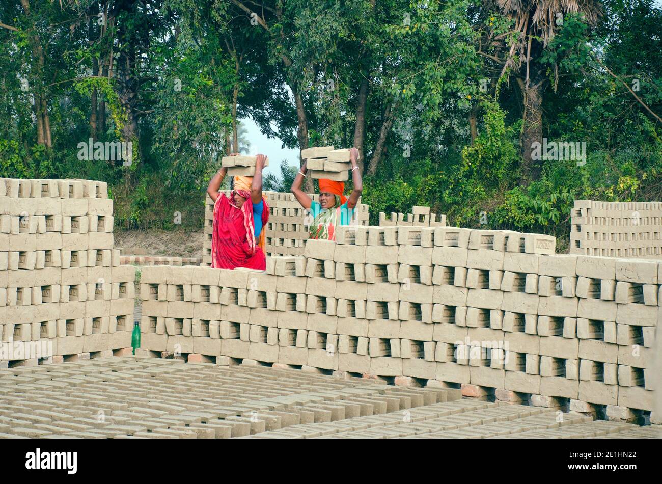 Immagine di un forno di mattoni nel remoto distretto di Hooghly. Lavoratori adulti lavorano duro per disporre i mattoni crudi nel forno per essere cotti. Foto Stock