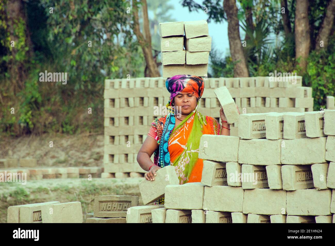 Immagine di un forno di mattoni nel remoto distretto di Hooghly. Lavoratori adulti lavorano duro per disporre i mattoni crudi nel forno per essere cotti. Foto Stock
