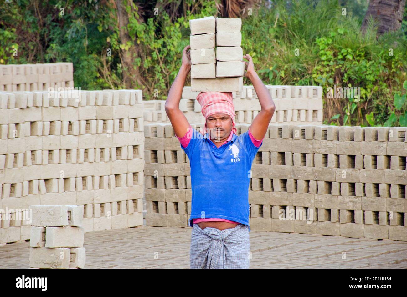 Immagine di un forno di mattoni nel remoto distretto di Hooghly. Lavoratori adulti lavorano duro per disporre i mattoni crudi nel forno per essere cotti. Foto Stock