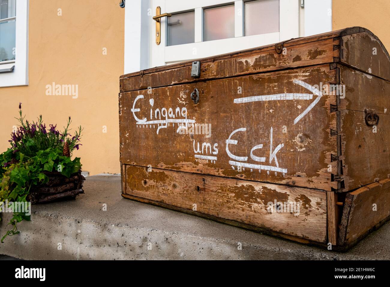 Antico petto di legno con iscrizione tedesca per l'ingresso dietro l'angolo, giorno nuvoloso in primavera in Austria Foto Stock