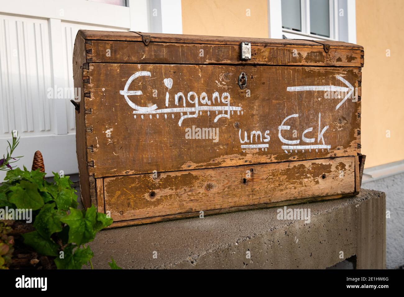 Antico petto di legno con iscrizione tedesca per l'ingresso dietro l'angolo, giorno nuvoloso in primavera in Austria Foto Stock