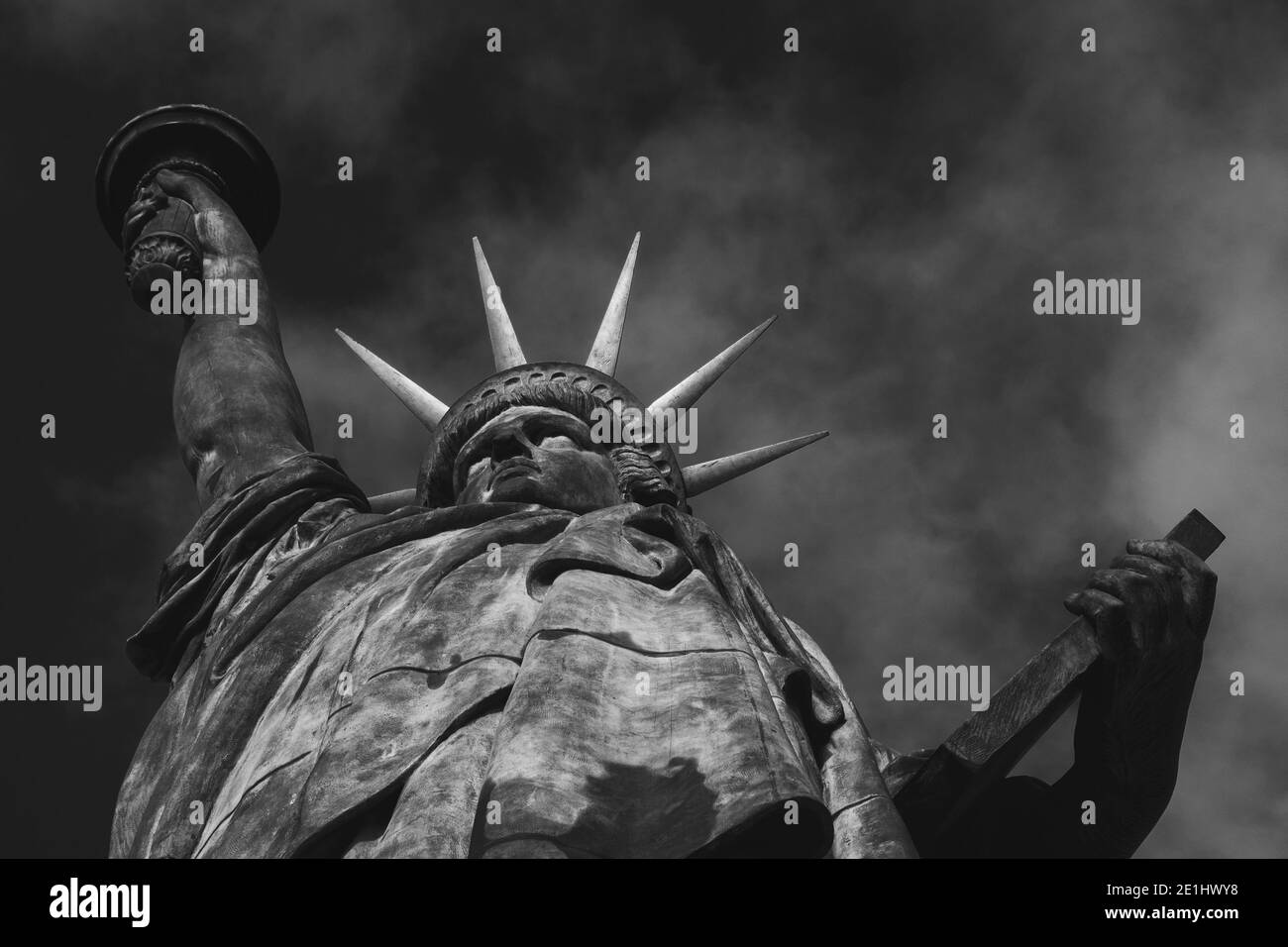 Statua della libertà all'Isola degli Swans a Parigi (Francia) contro il cielo con le nuvole sullo sfondo. Primo piano. Vista dal basso. Foto in bianco e nero. Foto Stock