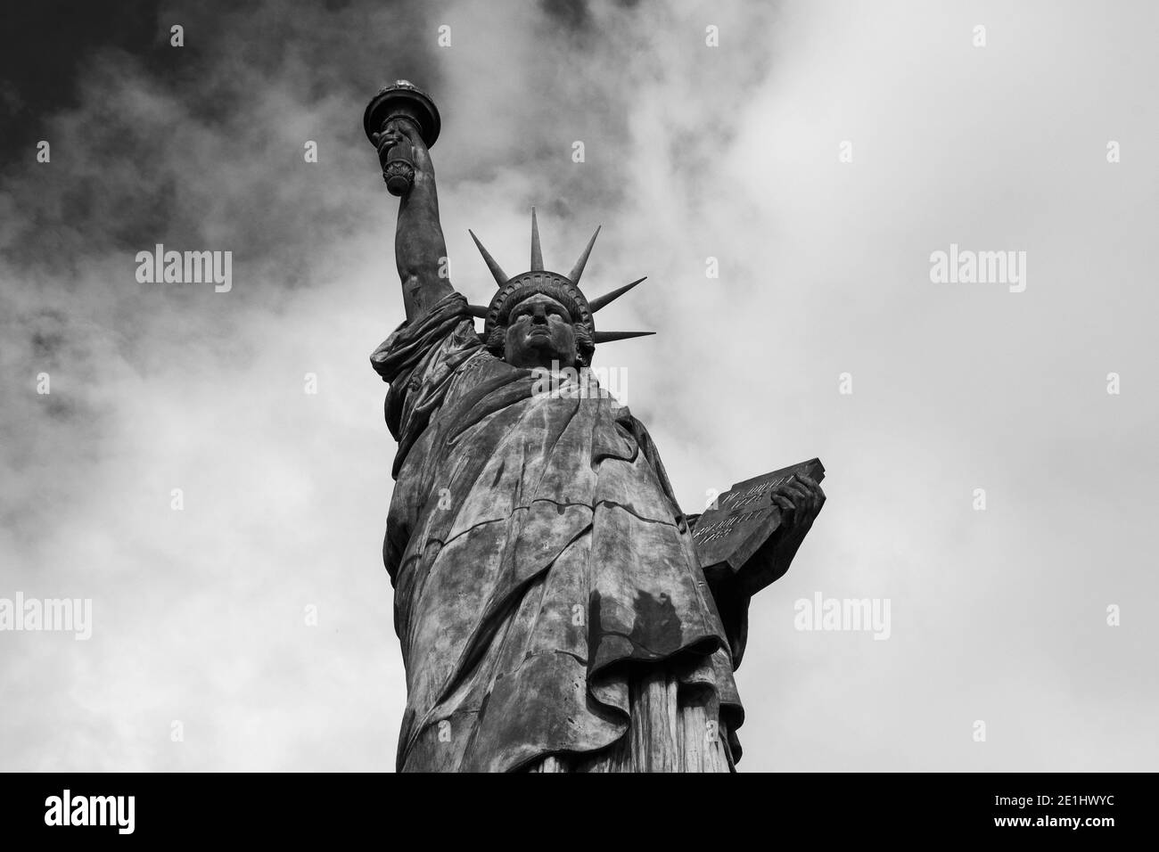 Statua della libertà all'Isola dei cigni a Parigi (Francia) contro il cielo con nuvole sullo sfondo. Primo piano. Vista dal basso. Foto storica in bianco e nero. Foto Stock