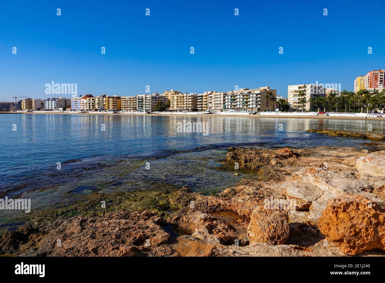 Riva rocciosa e linea di condominio e riflessioni a Torrevieja, sulla Costa Blanca della Spagna Foto Stock