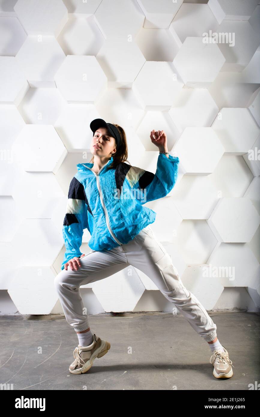 Cute teen dancing hip hop in pantaloni riflettenti, in uno studio con  illuminazione al neon. Poster a colori dance Foto stock - Alamy