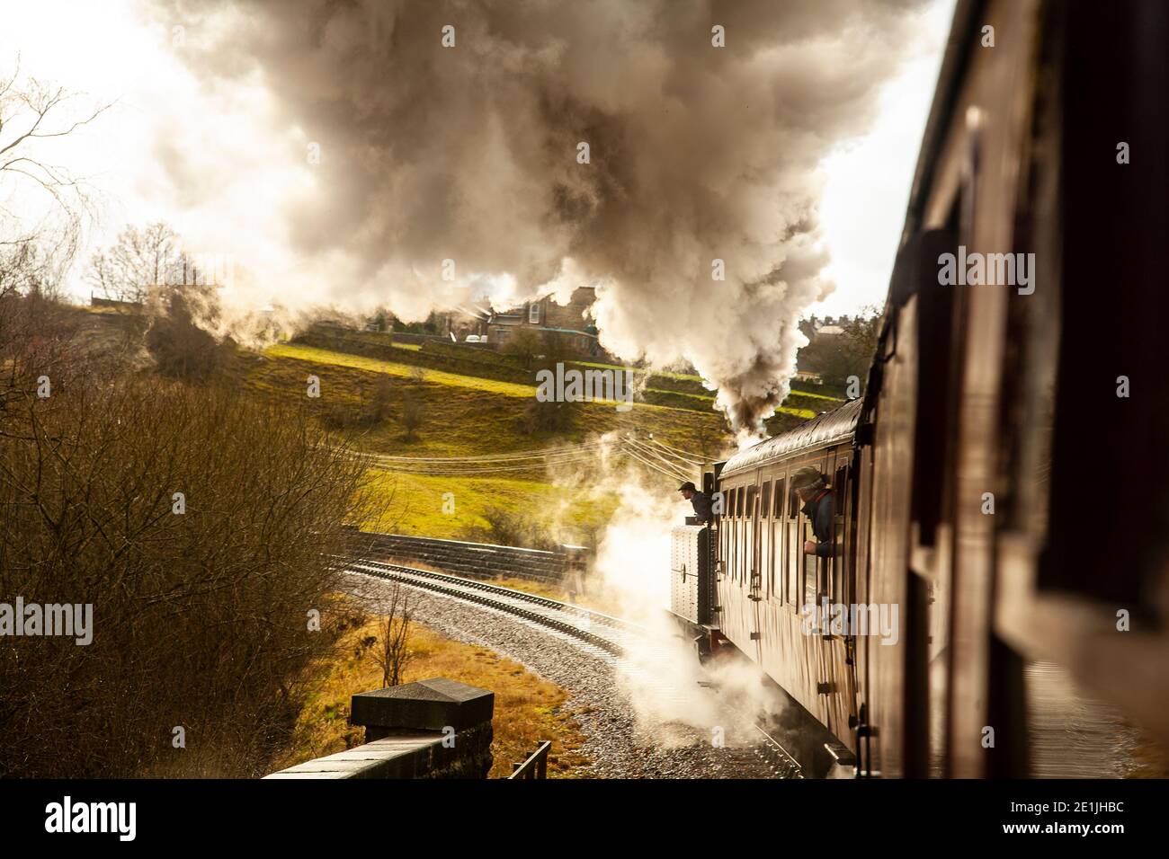 Locomotiva a vapore tradizionale che trasporta carrozze ferroviarie d'epoca e vapore in cinghia Potenza attraverso una pendenza sulla Keighley & Worth Valley linea heritage Foto Stock