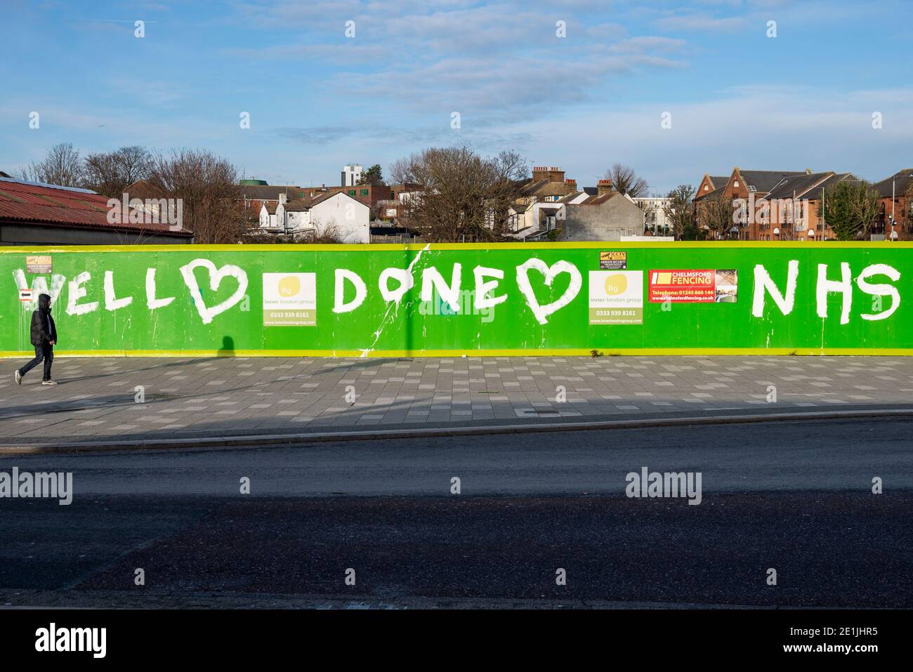 Southend on Sea, Essex, Regno Unito. 7 gennaio 2021. Dopo aver affrontato le critiche per l'affollato lungomare Southend Borough Council ha chiuso il parcheggio per auto fronte mare per scoraggiare i visitatori durante COVID 19. La mattina è scoppiata in un pomeriggio di sole che attrae alcune persone fuori per l'esercizio ma non in gran numero. Una persona che cammina oltre il sito di costruzione ritardato con messaggio di ringraziamento per NHS Foto Stock