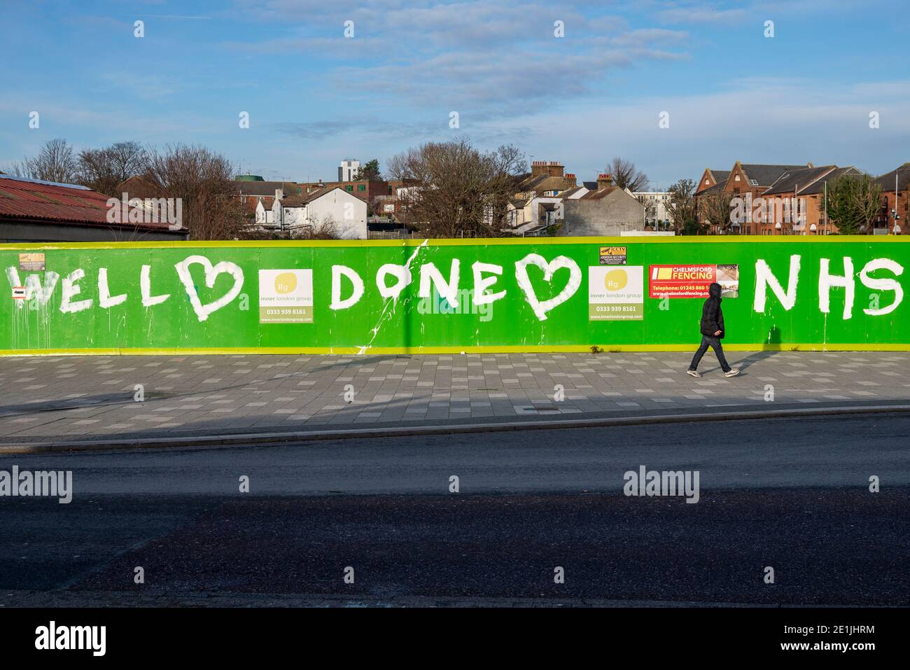 Southend on Sea, Essex, Regno Unito. 7 gennaio 2021. Dopo aver affrontato le critiche per l'affollato lungomare Southend Borough Council ha chiuso il parcheggio per auto fronte mare per scoraggiare i visitatori durante COVID 19. La mattina è scoppiata in un pomeriggio di sole che attrae alcune persone fuori per l'esercizio ma non in gran numero. Una persona che cammina oltre il sito di costruzione ritardato con messaggio di ringraziamento per NHS Foto Stock