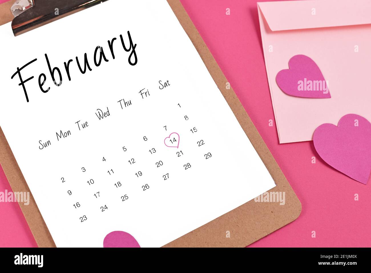 Foglio di calendario di febbraio con San Valentino il 14 ° segnato con cuore circondato da cuori e lettera d'amore su rosa sfondo Foto Stock