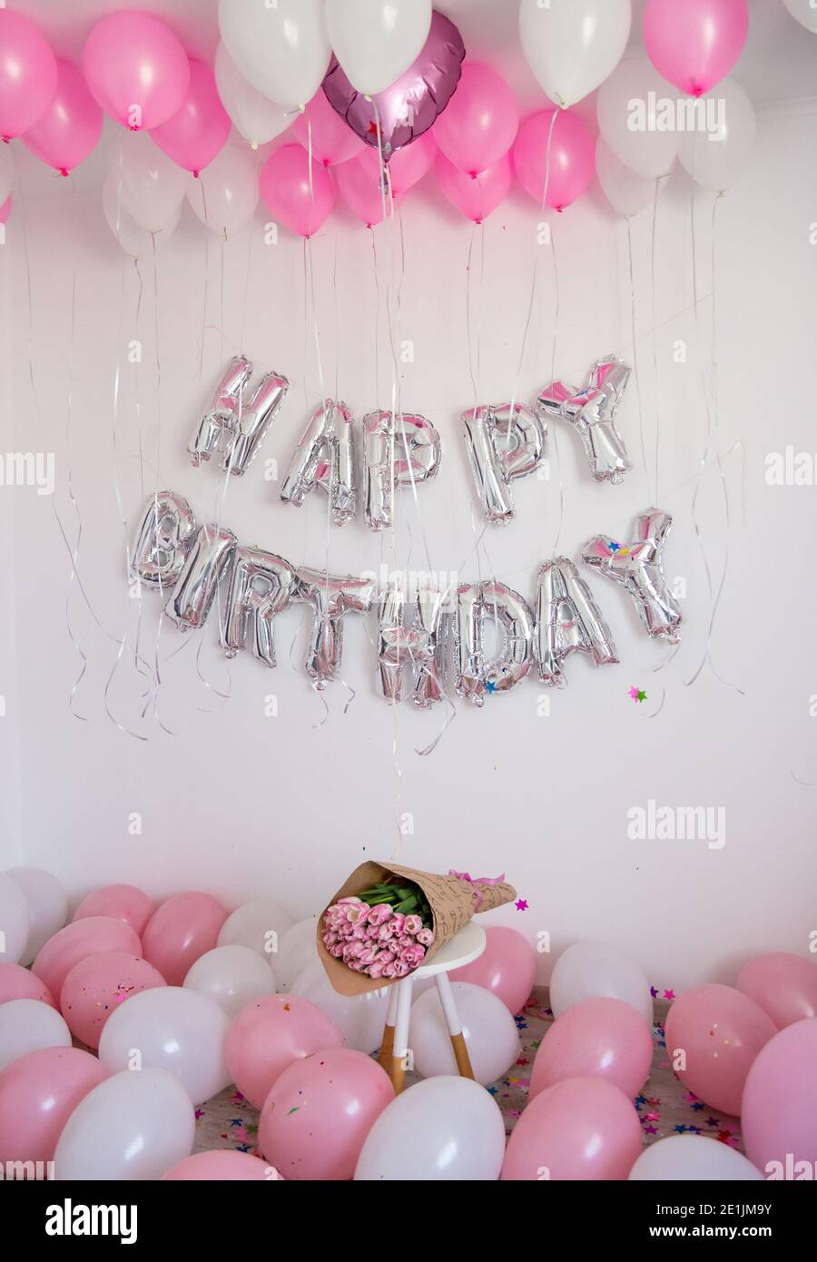 Decorazioni di compleanno con palloncini, bouquet di tulipani e confetti  per la festa Foto stock - Alamy