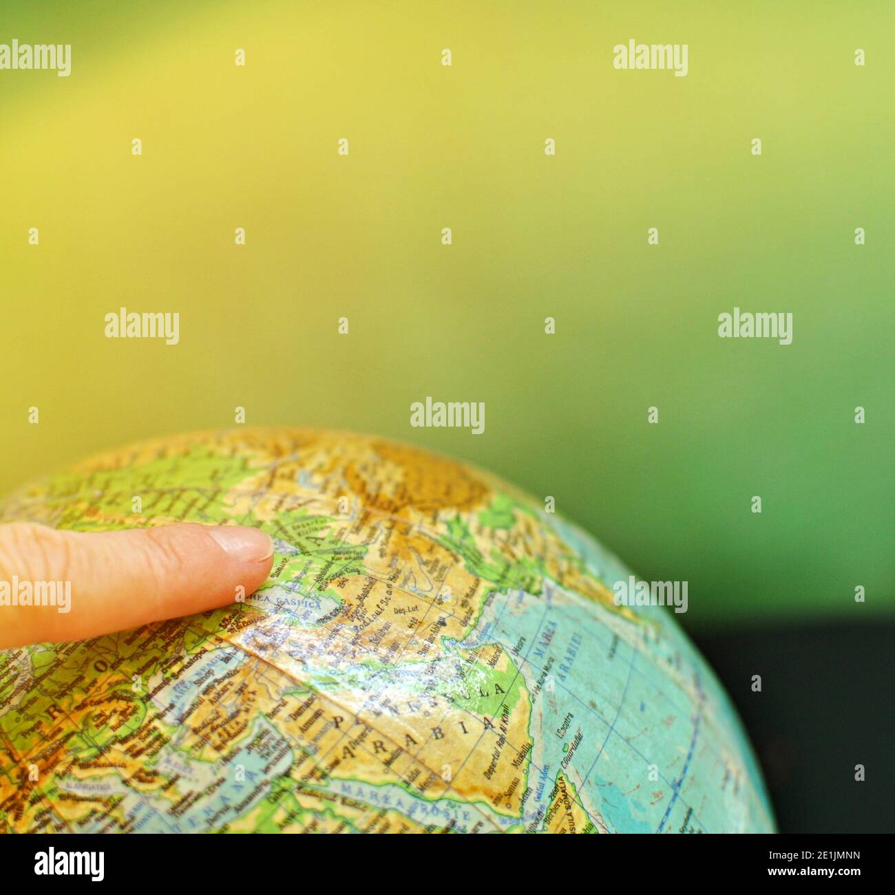 Primo piano di una mappa mondiale con un dito indice. Concetto di viaggio, esplorazione o ricerca della destinazione. Alleggerimento dall'alto Foto Stock
