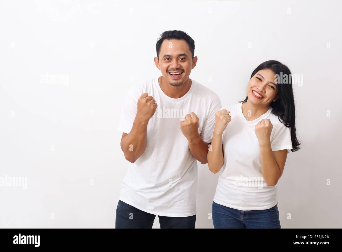 Ritratto di allegro popolo asiatico uomo e donna in bianco camicia sorridente e accanito pugni come vincitori o persone felici isolato su sfondo bianco Foto Stock