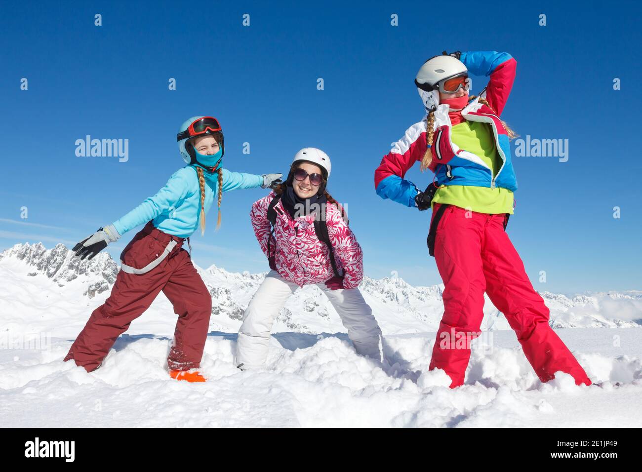 Attività nella neve di tre ragazze in inverno Vacanze nelle Alpi francesi nella neve con colorfull giacca e casco da sci Foto Stock