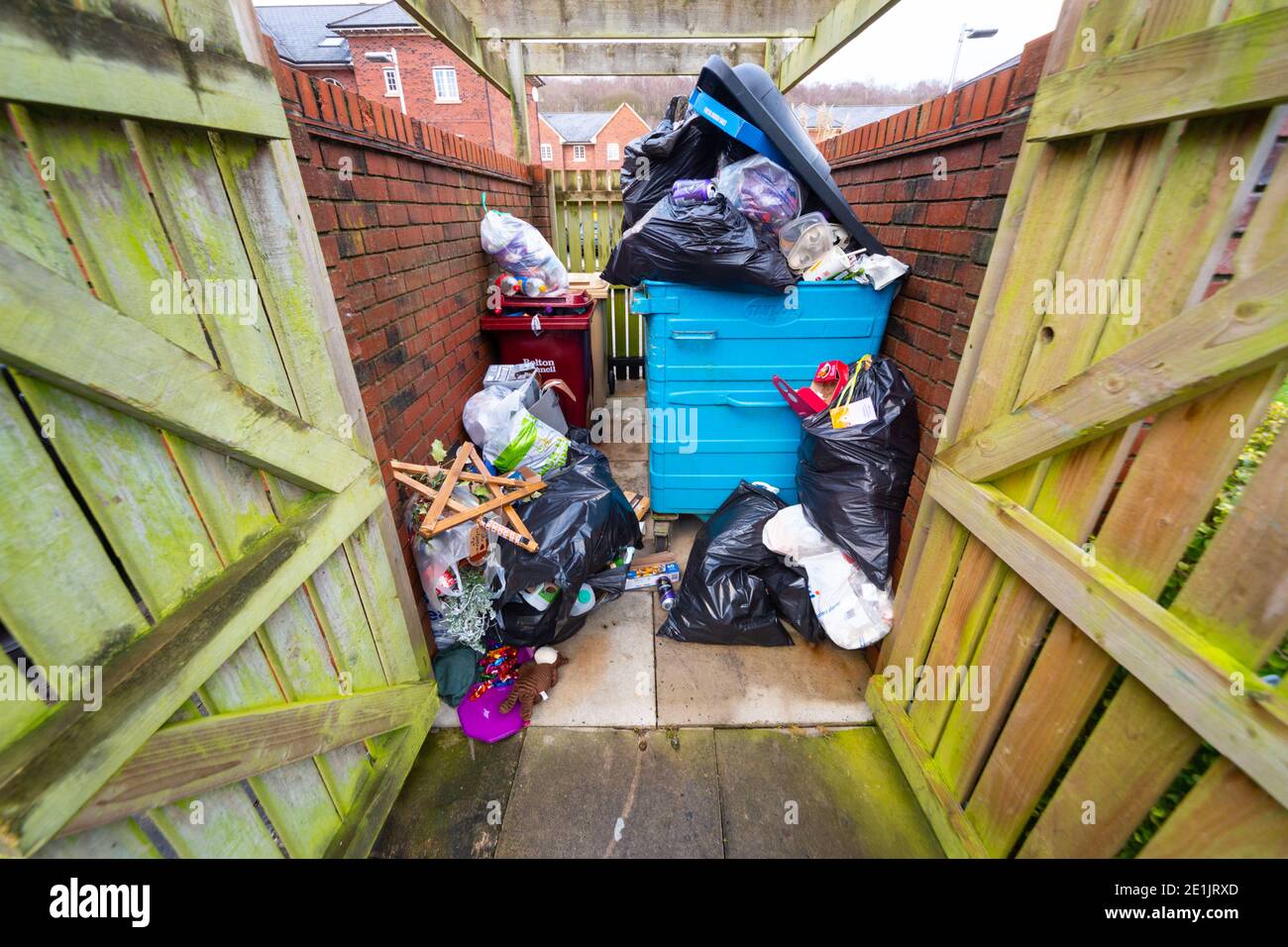 Contenitori pieni e traboccanti, wastbin, trashcan, ricettacolo, rifiuti in un deposito di bidoni residenziale su una tenuta di alloggi del Regno Unito, Inghilterra, Regno Unito. Rifiuti, rifiuti Foto Stock