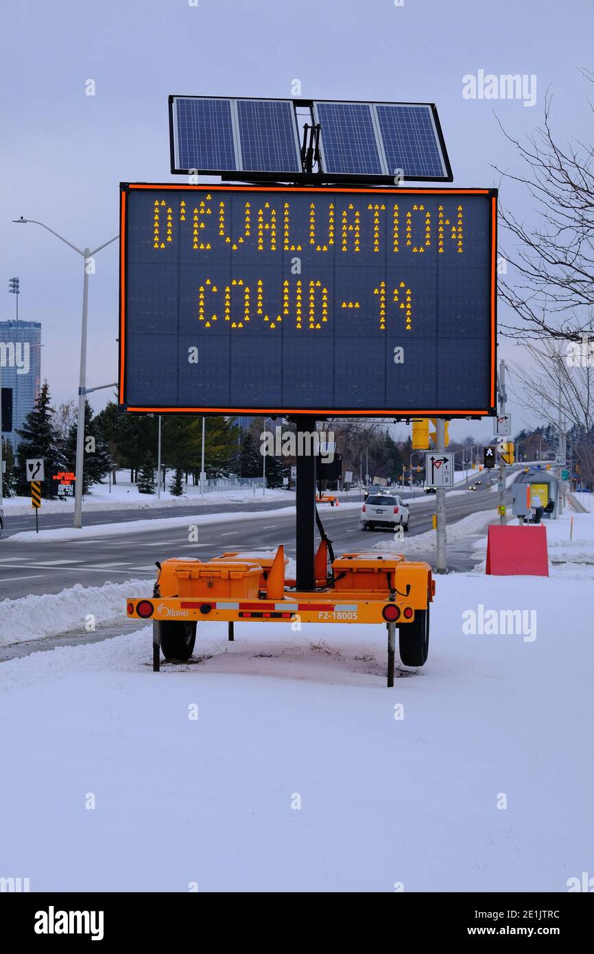 COVID-19 cartello stradale provvisorio nella neve su Bronson Avenue che dirige la gente al luogo di prova della Brewer Park Arena, Ottawa, Ontario, Canada. Foto Stock