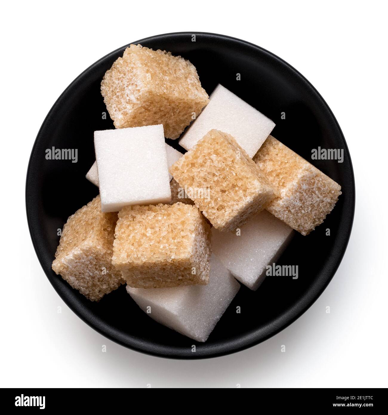 Cubetti di zucchero bianco e marrone in ciotola di ceramica nera isolata su bianco. Vista dall'alto. Foto Stock