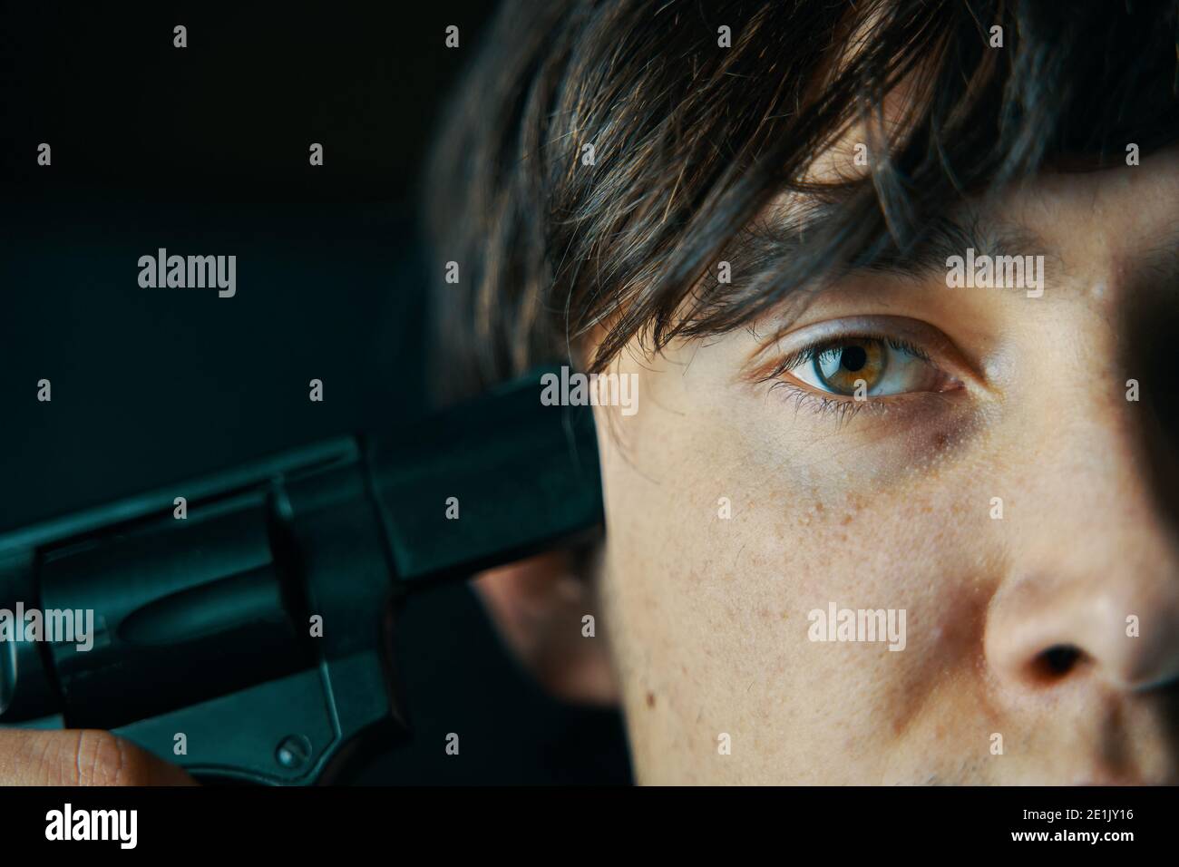 Il giovane mise il muso della pistola al suo tempio. Guy si suiciderà. Maschio vuole sparare con una pistola. Foto Stock