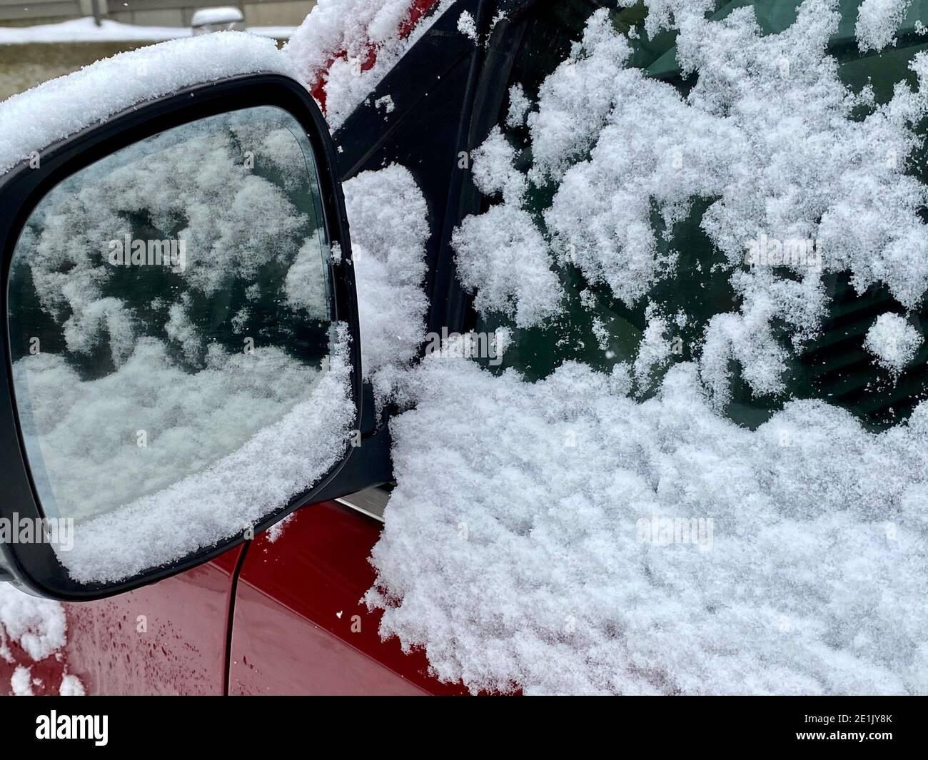 Neve fresca e fiocchi di neve sulla parte superiore delle finestre rosse dell'automobile dopo la caduta di neve all'inizio di dicembre in Vermont, Stati Uniti Foto Stock
